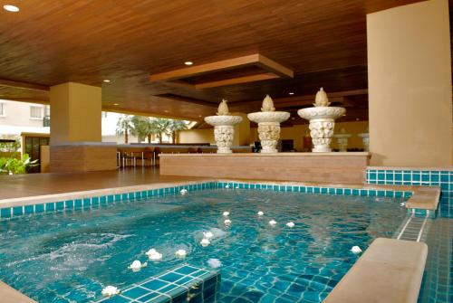 a swimming pool with white columns in a building at The Narathiwas Hotel & Residence Sathorn Bangkok in Bangkok