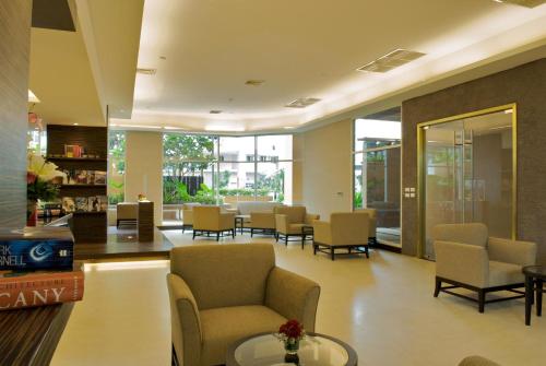 a waiting room with chairs and tables and windows at The Narathiwas Hotel & Residence Sathorn Bangkok in Bangkok