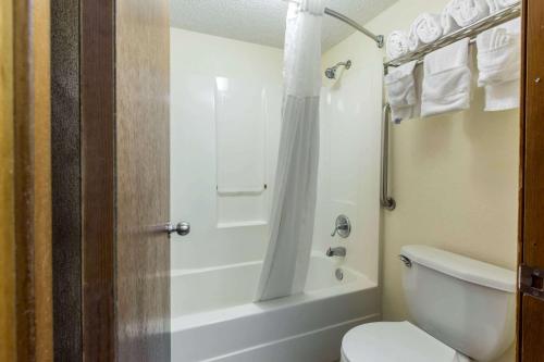 Quality Inn Cordele في كورديل: حمام مع مرحاض وحوض استحمام ودش
