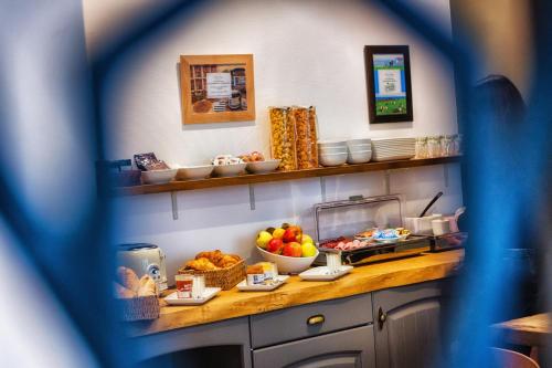 a kitchen with a counter with bowls of food on it at Hôtel Victor Hugo Lorient in Lorient