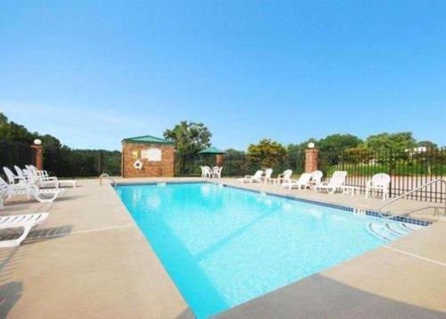 una gran piscina con sillones blancos en Quality Inn Dahlonega Near University, en Dahlonega