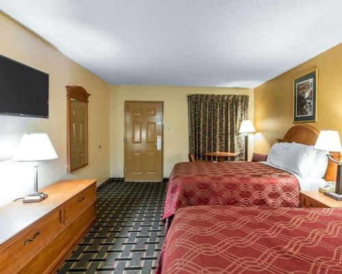 una camera d'albergo con due letti e una TV a schermo piatto di Econo Lodge Dalton West a Dalton