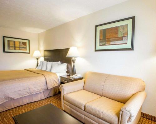 a hotel room with a bed and a couch at Quality Inn Dahlonega Near University in Dahlonega