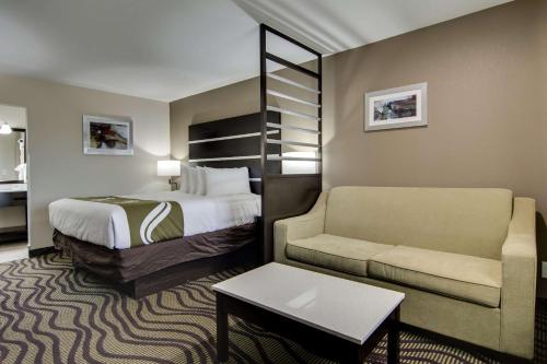 アセンズにあるQuality Inn & Suites Athens University Areaのベッドとソファ付きのホテルルーム