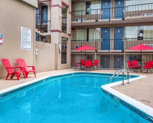 a swimming pool with red chairs and a hotel at Econo Lodge in Atlanta
