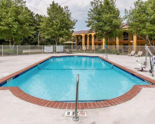 una piscina in un cortile con una casa sullo sfondo di Econo Lodge Dalton West a Dalton