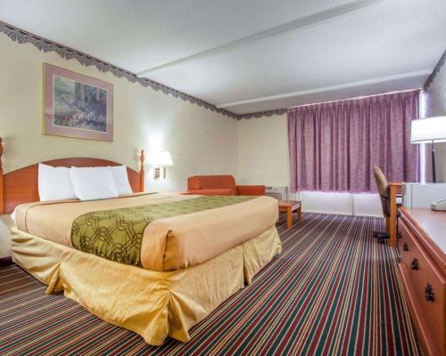 um quarto de hotel com uma cama grande e uma secretária em Rodeway Inn Stone Mountain em Tucker