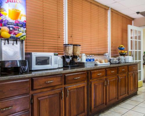 a kitchen with wooden cabinets and a microwave at Econo Lodge Atlanta College Park in Atlanta