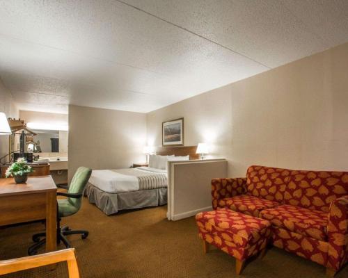 um quarto de hotel com uma cama e um sofá em Econo Lodge Inn & Suites at Fort Moore em Columbus