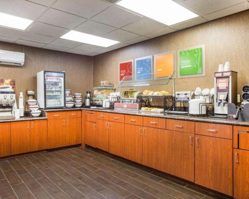 a fast food kitchen with wooden cabinets and a counter at Comfort Inn & Suites at Stone Mountain in Stone Mountain