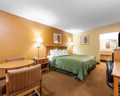 a hotel room with a bed and a table at Quality Inn & Suites in Cartersville