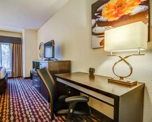 a hotel room with a desk and a chair at Comfort Suites Northside Hospital Gwinnett in Lawrenceville