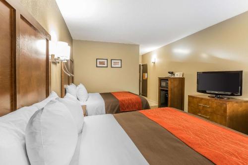 a hotel room with two beds and a flat screen tv at Comfort Inn & Suites Dalton West in Dalton