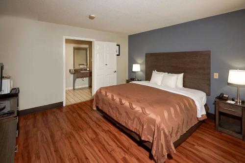 a hotel room with a bed and a bathroom at Quality Inn Augusta West Near Fort Eisenhower in Augusta