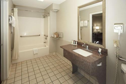 y baño con lavabo, ducha y espejo. en Quality Inn Augusta West Near Fort Eisenhower en Augusta