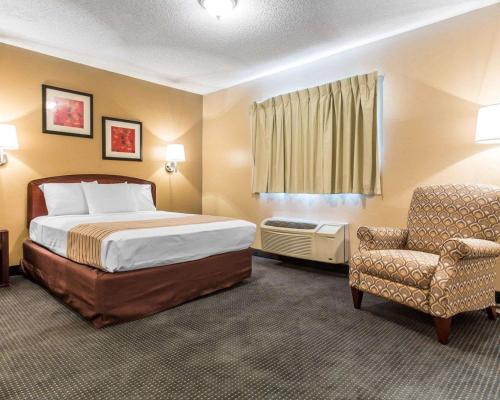 a hotel room with a bed and a chair at Suburban Studios Kennesaw-Marietta North in Kennesaw