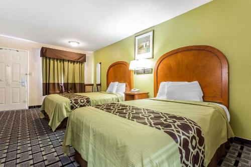 a hotel room with two beds with green walls at Rodeway Inn Augusta South in Augusta