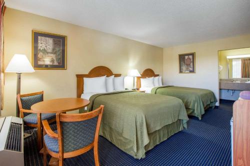 アメリカスにあるQuality Inn Americusのベッド2台とテーブルが備わるホテルルームです。
