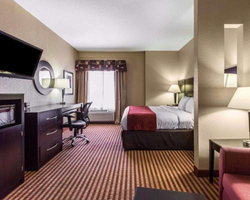 a hotel room with a bed and a desk at Comfort Suites Waycross in Waycross