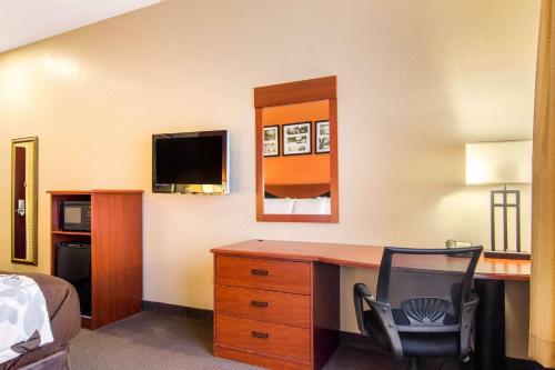 a bedroom with a desk and a bed and a television at Sleep Inn & Suites Athens South in Athens