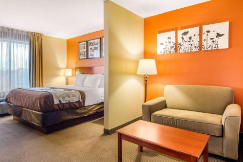 a hotel room with a bed and a chair at Sleep Inn & Suites Athens South in Athens