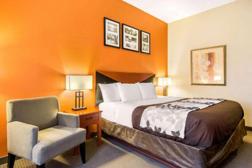 a hotel room with a bed and a chair at Sleep Inn & Suites Athens South in Athens