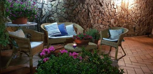 a patio with chairs and a table and flowers at Marco's house in Dolianova