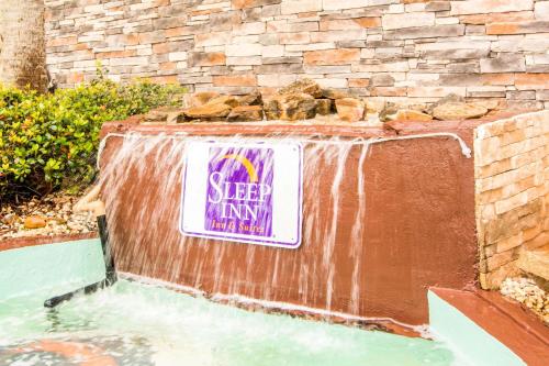a waterfall in a yard with a sign on it at Sleep Inn & Suites Athens South in Athens