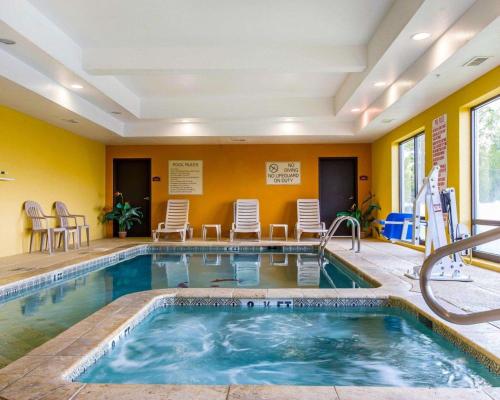 a pool in a hotel room with chairs and a swimming pool at Comfort Suites Waycross in Waycross