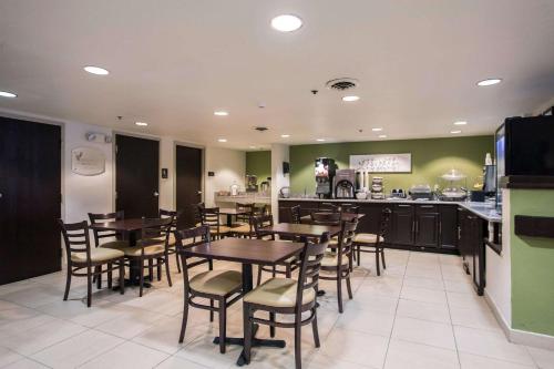 a restaurant with tables and chairs and a kitchen at Sleep Inn Atlanta Airport in Atlanta