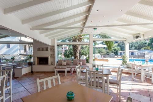 a patio with tables and chairs and a fireplace at Anita in Perama