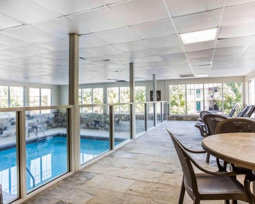 Großes Zimmer mit Pool, Tischen und Stühlen in der Unterkunft Comfort Inn & Suites Ballpark Area in Atlanta