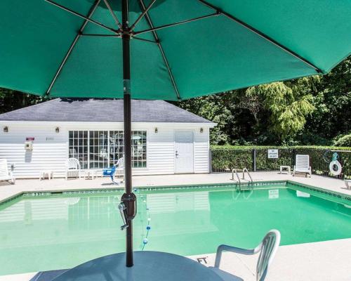 a green umbrella sitting next to a swimming pool at Quality Inn Conyers I-20 in Conyers