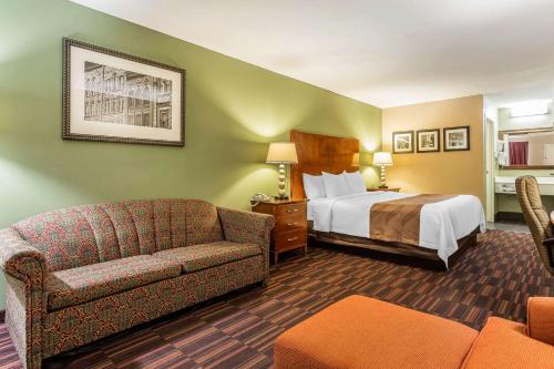 a hotel room with a bed and a couch at Quality Inn & Suites near Robins Air Force Base in Warner Robins