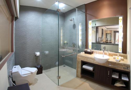 a bathroom with a shower and a toilet and a sink at d'Penjor Seminyak in Seminyak