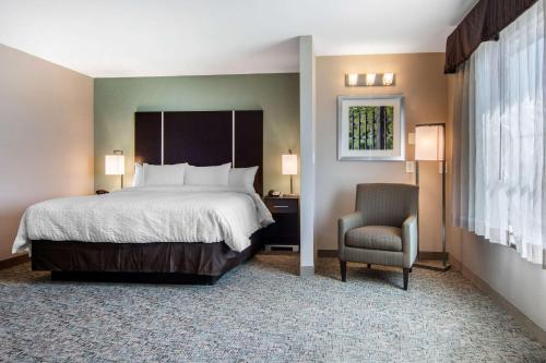a hotel room with a bed and a chair at Clarion Inn & Suites Atlanta Downtown in Atlanta