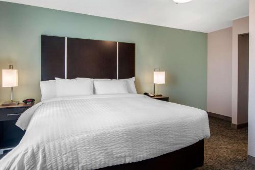 a large bed in a hotel room with two lamps at Clarion Inn & Suites Atlanta Downtown in Atlanta