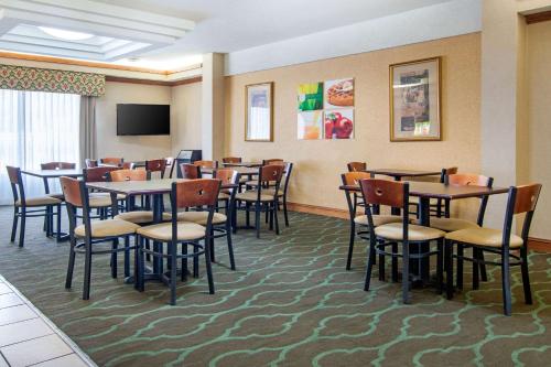 a dining room with tables and chairs and a tv at Quality Inn & Suites Decatur - Atlanta East in Decatur