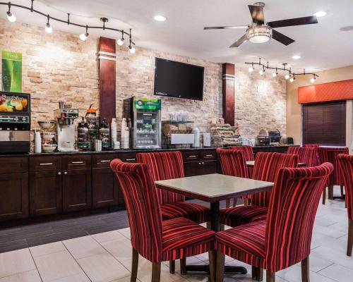 a bar with red chairs and a table in a restaurant at Quality Inn & Suites Des Moines Airport in Des Moines