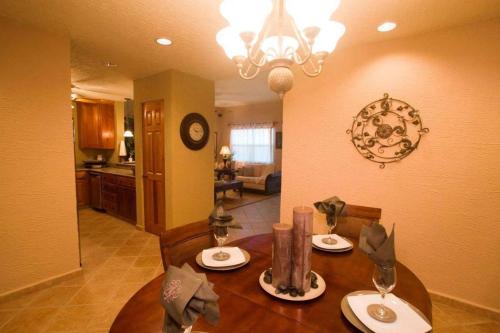 a dining room table with two chairs and a chandelier at Clarion Suites Roatan at Pineapple Villas in First Bight
