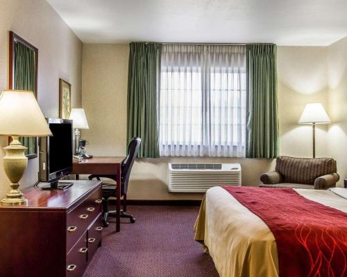 Quality Inn & Suites Fort Madison near Hwy 61 في Fort Madison: غرفة في الفندق بها سرير ومكتب وبه جهاز كمبيوتر
