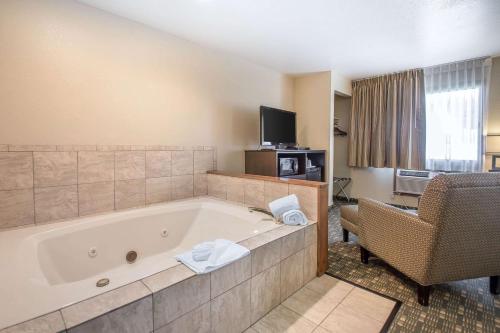 a bathroom with a tub and a couch and a chair at Quality Inn & Suites Decorah in Decorah