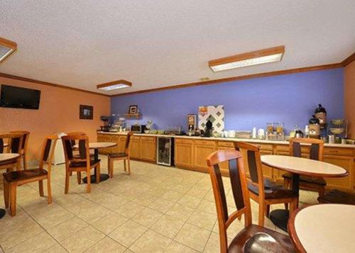 una sala con tavoli e sedie e una cucina di Quality Inn & Suites Grinnell near University a Grinnell