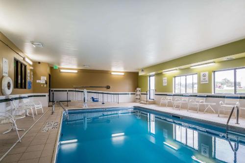 a swimming pool with a pool table and chairs in it at Quality Inn - Coralville in Coralville