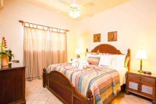 a bedroom with a bed and a ceiling fan at Clarion Suites Roatan at Pineapple Villas in First Bight