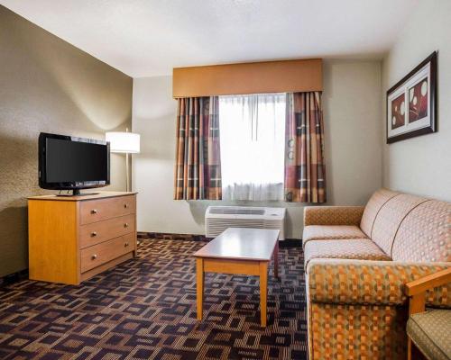 a hotel room with a couch and a tv at Quality Inn & Suites Des Moines Airport in Des Moines