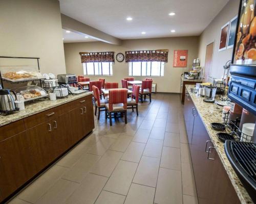 Comfort Inn & Suites Riverview near Davenport and I-80 في Le Claire: مطعم مع مطبخ وغرفة طعام