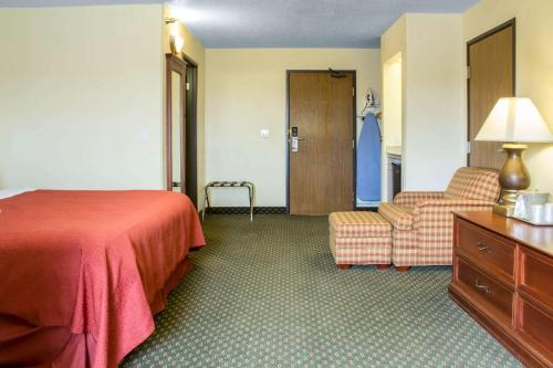 a hotel room with a bed and a chair at Quality Inn & Suites Sioux City Southeast in Sioux City