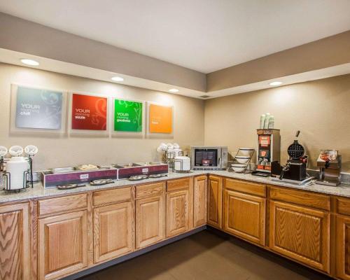 a kitchen with wooden cabinets and a counter top at Comfort Inn Marshalltown South in Marshalltown