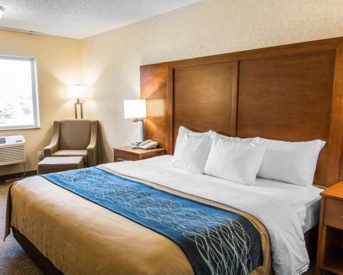 a hotel room with a large bed and a chair at Quality Inn Lewiston in Lewiston